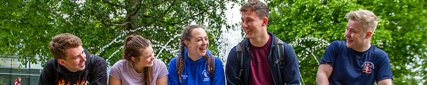 students smiling sat on a bench